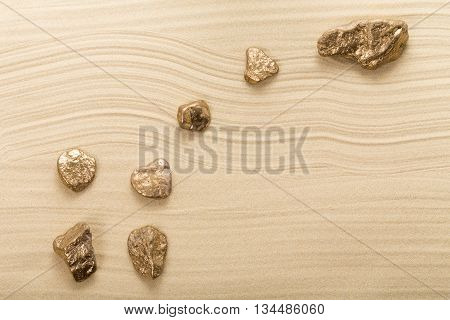Golden stones in form of constellation Ursa Minor on waved sand. Photo can be used as a whole background.