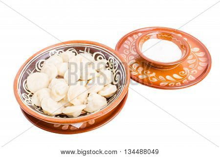 Russian dumplings pelmeni with minced beef meat. Served with sour cream. Isolated on a white background.