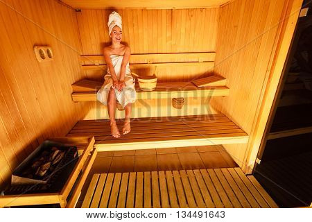 Woman Sitting Relaxed In Wooden Sauna