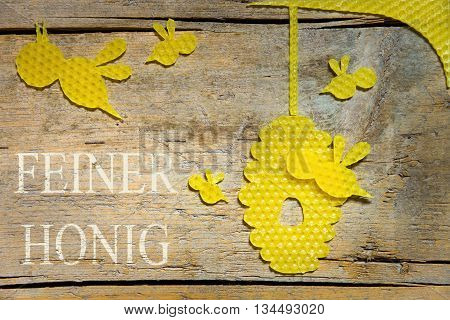 Beeswax, Bees And A Beehive On Wooden Table, German Text, Delicious Honey