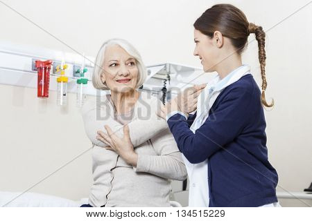 Physiotherapist Helping Smiling Senior Patient With Hand Exercis