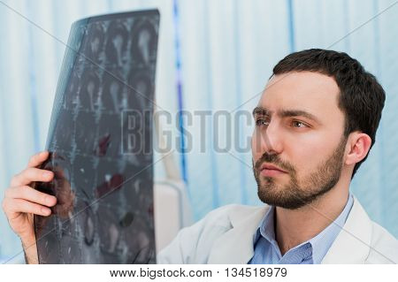 Portrait of mid-adult male doctor in MRI room at hospital.