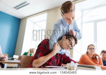 education, bullying, violence, aggression and people concept - student boy suffering of classmate mockery
