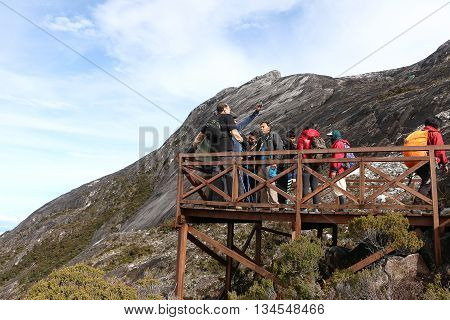 MOUNT KINABALU, SABAH BORNEO MALAYSIA - JUNE 12, 2016: Unidentified hikers having rest and enjoying the view of Ranau at the balcony of Mount Kinabalu new route trail.