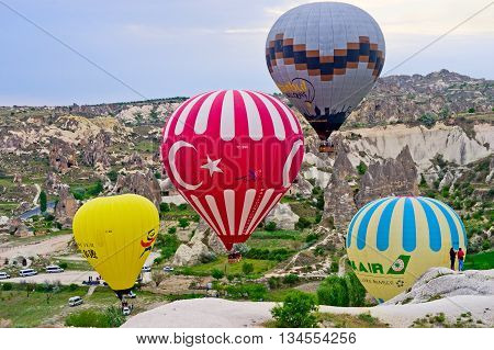 Hot Air Balloons Over Mountain Landscape In Cappadocia