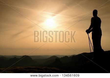 Silhouette Of Tourist With Poles In Hand. Sunny Spring Daybreak