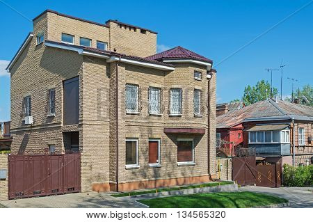 A small brick house covered with a red metal tile