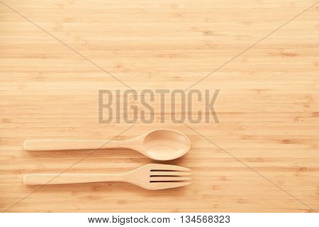 Wooden spoon and fork on wood texture of dining table from top view - use for background in kitchen and food concept