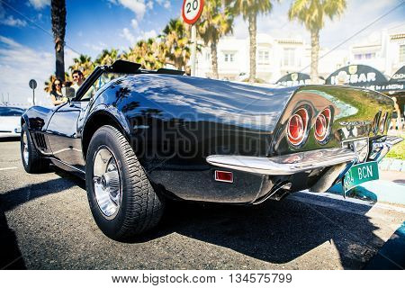 Benalmadena, Spain - June 21, 2015: A black Chevrolet Corvette C3, back view, parked in the port of Benalmadena (Spain), on June 21, 2015.