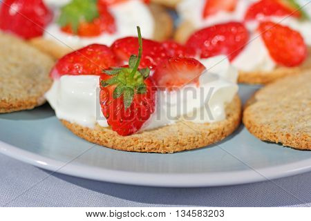 Oat buiscits with cream and fresh strawberries close up