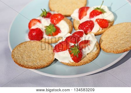 Oat buiscits with cream and fresh strawberries close up