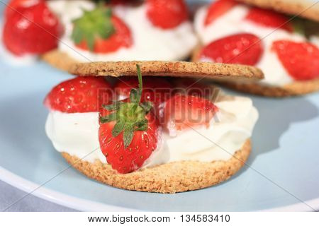 Oat buiscits with cream and fresh strawberries close up