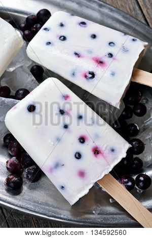 Homemade popsicles from yogurt blueberry and blackcurrant close up view