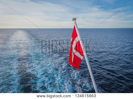 Danish flag hanging from the stern of a ferry a ship crossing the north sea
