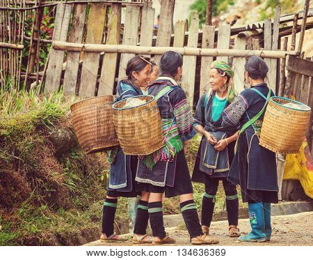 SAPA, VIETNAM - OCTOBER 29, 2012: Hmong women sell souvenirs in Sapa. The Hmongs are known for their colorful clothes and silver jewelry. Hmong women have various clothes colours and style