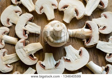Cut champignons settled into geometrical patterns on a wooden background