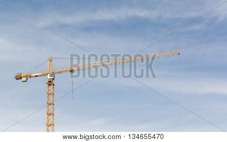 Huge crane and construction plant. Big construction crane and the building against the sky background. Tower Crane in Construction site.