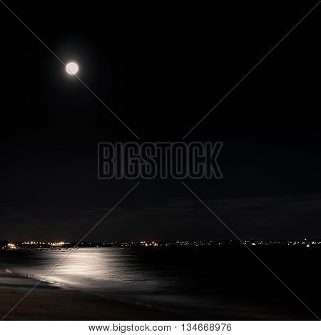 Beautiful view of a city at night with a moon shining on it.