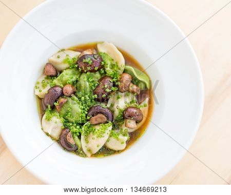 Delicious dumpling soup with mushrooms and herbs