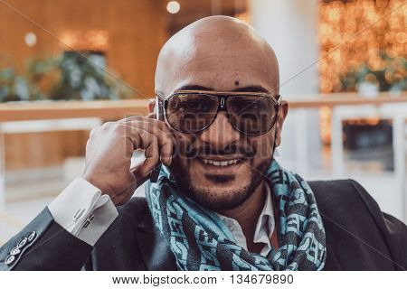 Arab businessman talking on mobile phone at a shopping center