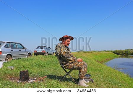 The river Kargat Novosibirsk oblast Siberia Russia - June 12 2016: fisherman drinking tea and admiring the beauty of the river