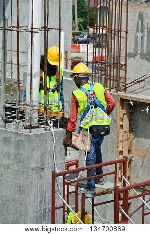 MALACCA, MALAYSIA -MARCH 13, 2016: Construction workers at the construction site in Malaysia. All of them is required to wear adequate safety equipment during works to make sure their safety.