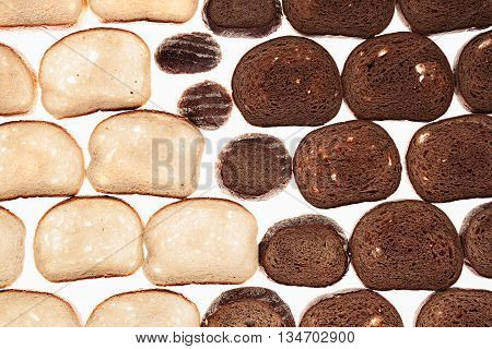 Slices of black rye bread and white bread on a white background. Food background. Pattern.