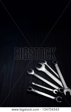 Several of wrenches on dark wooden board