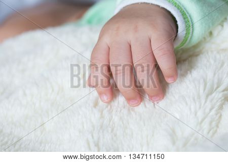 Asian baby sleeping on the bed with five finger