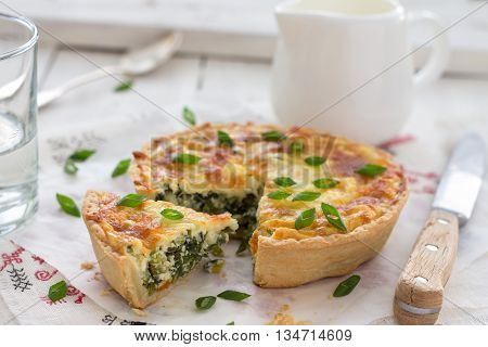 Mini quiche with green onions and cheese on a light wooden background, selective focus