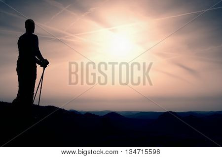 Silhouette Of Tourist With Poles In Hand. Sunny Spring Daybreak