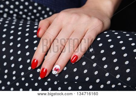 Closeup of painted red nails with flower motive
