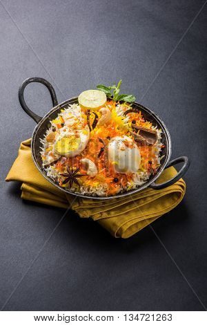 Basmati rice slowly cooked with Masala roasted egg and spices served in kadhai or kadai with yogurt dip, selective focus, egg biryani or anda rice or egg rice