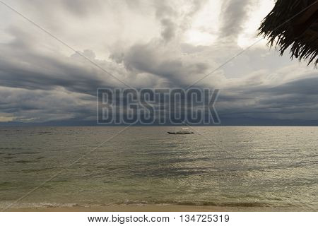 philippine wooden boat waiting tropical storm on surface calm sea under dark sky
