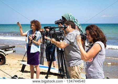 Odesa, Ukraine - June 4, 2016: TV camera man filming a beach sport event, windsurfing competition