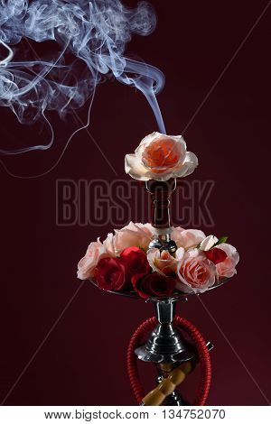 Asian hookah decorated with flowers on dark background