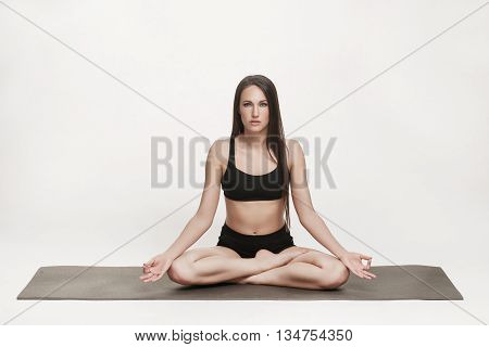 Portrait of young attractive woman doing yoga. Brunette with fit body on yoga mat. Healthy lifestyle and sports concept. Series of exercise poses.