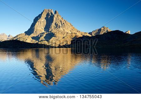 Midi Dossau Peak reflected in Gentau lake. Ossau Valley, Pyrenees National Park, Pyrenees, France.