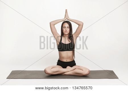 Portrait of young attractive woman doing yoga. Brunette with fit body on yoga mat. Healthy lifestyle and sports concept. Series of exercise poses.