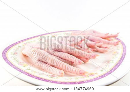 chicken feet in dish on white background