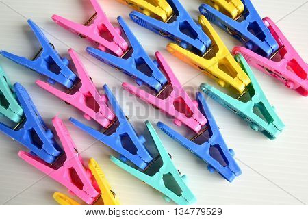 Many Colorful Clothes Pegs on white background
