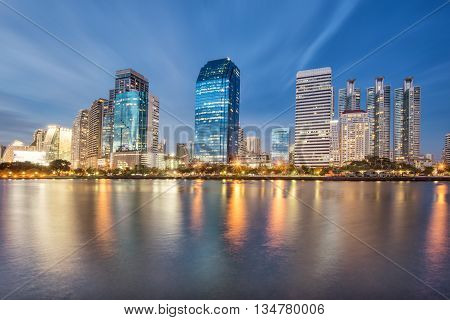 Bangkok cityscape at night with water refact