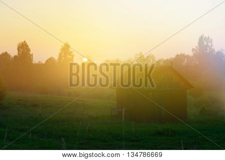 Sunset landscape. Hounting lodge in the forest in Russia