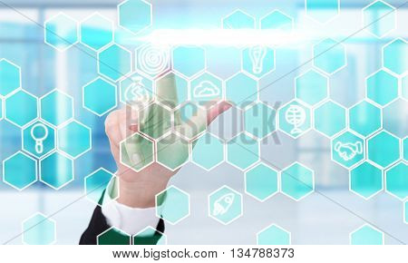 Business concept with businesswoman hand pressing digital honeycomb patterns with business icons
