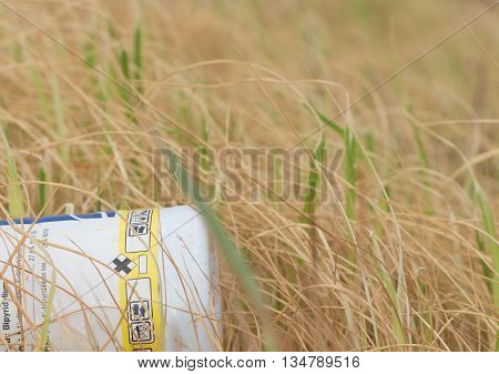 yellow grass damaged by herbicide and part of bottle herbicide