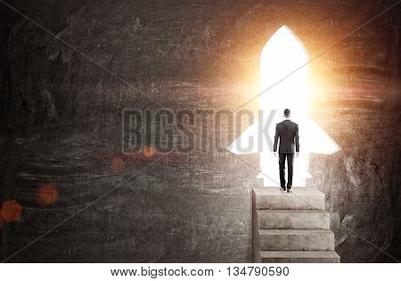 Startup concept with businessman standing on concrete stairs against rocket shaped door with bright light. Chalkboard background