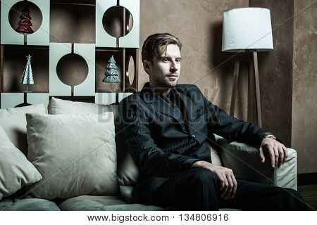 Businessman sitting on an armchair. Fahion man.