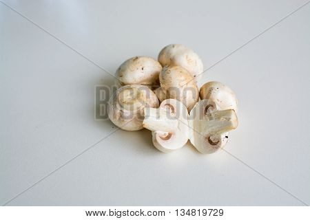 White champignon mushrooms and sliced mushrooms isolated on light background