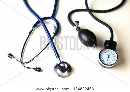 Medical stethoscope and blood pressure cuff on the table.