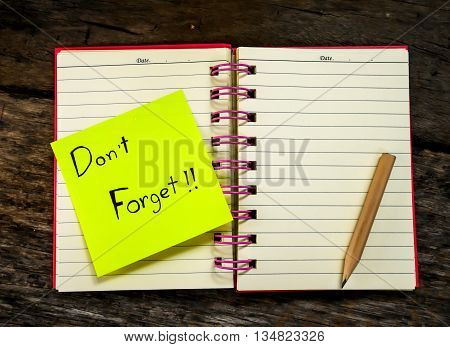 Reminder paper note in note book on wooden table